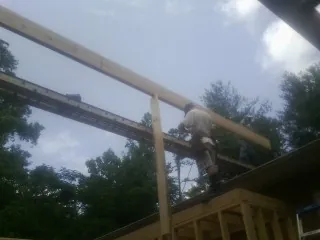 Carpenter setting a ridge beam over a new addition frame — Ice Dam Removal by Roofing Brothers in Stahlstown