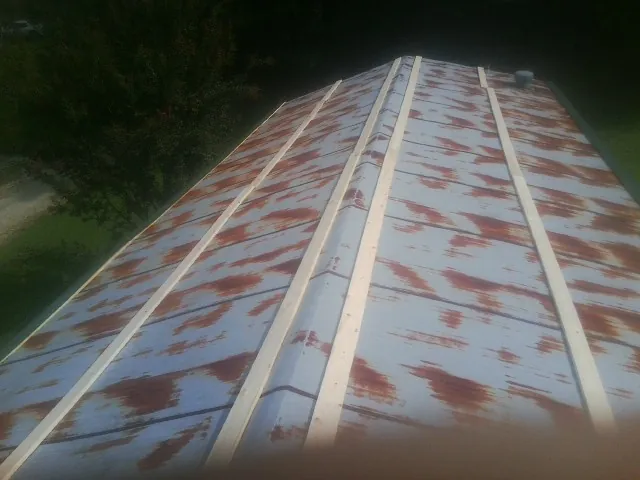 Rusted metal roof panels with new wood purlins before replacement — Storm Damage Roof Repair in Stahlstown by Roofing Brothers