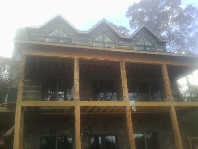 Dormers and porch framing on a large log home under construction — Roof Coating work by our crew in Stahlstown