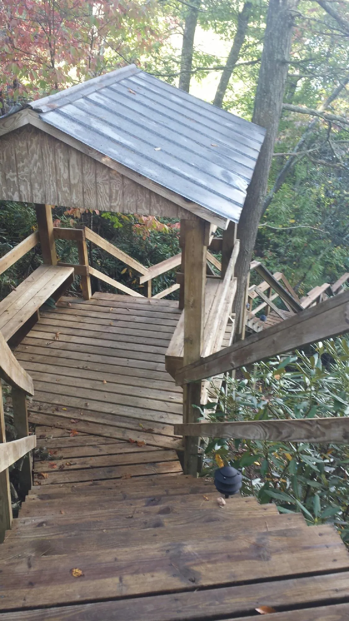 Metal roofed shelter over wooden steps on a wooded walkway — Skylight Repair & Installation work by our crew in Stahlstown