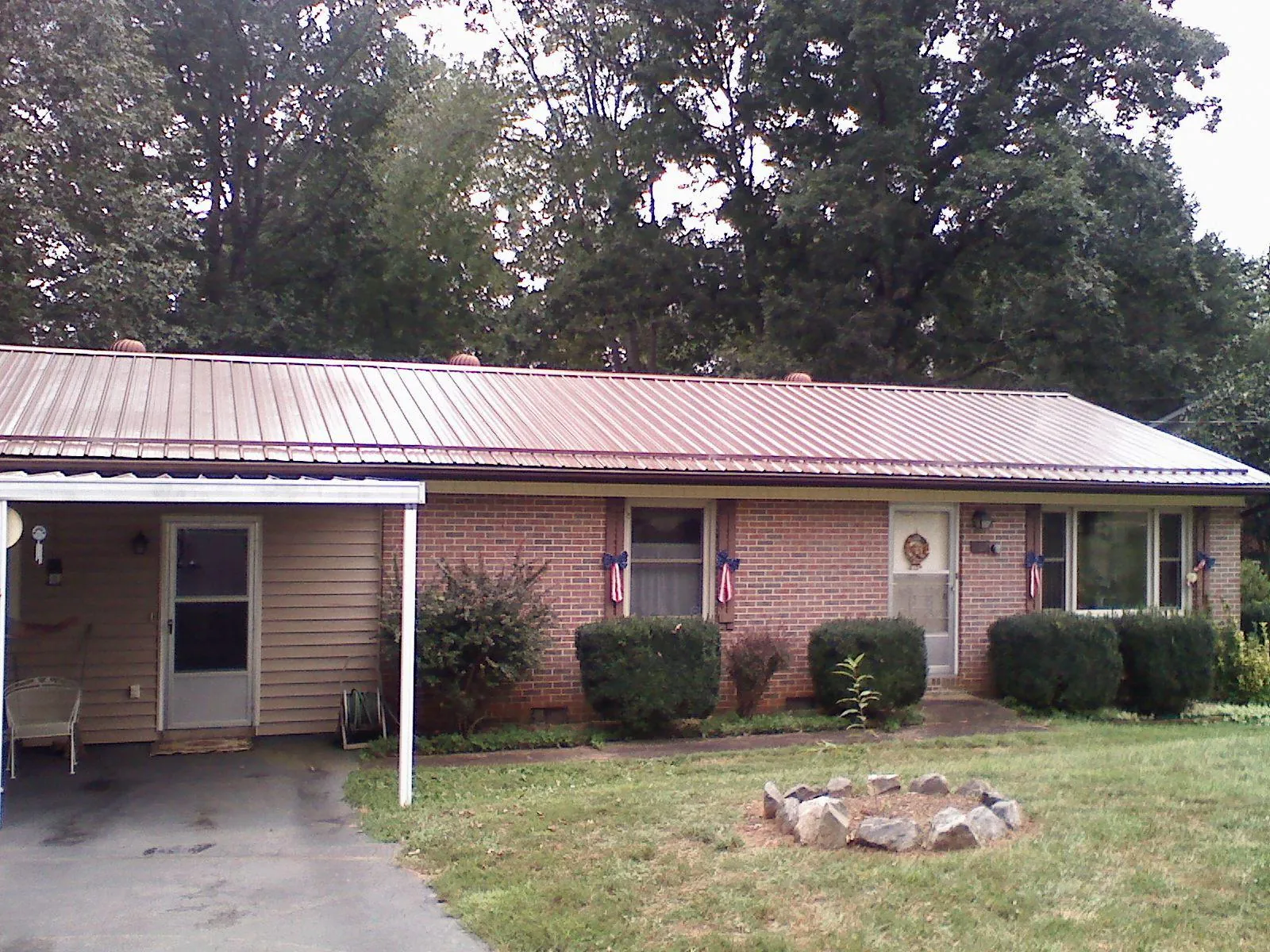 Bronze metal roof and carport on a brick ranch home — Roof Repair work by our crew in Stahlstown