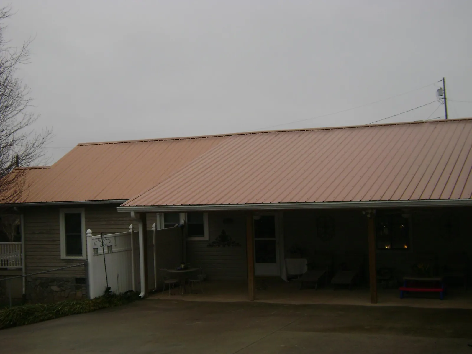 Copper toned metal roof over a wide covered patio in Stahlstown